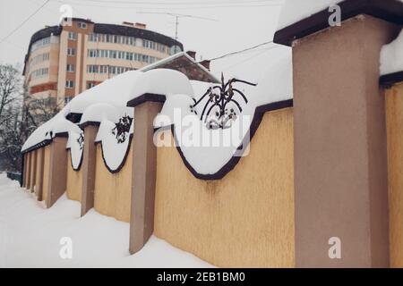 Clôture en pierre avec détails métalliques recouverts d'une épaisse couche de neige après blizzard. Banque D'Images