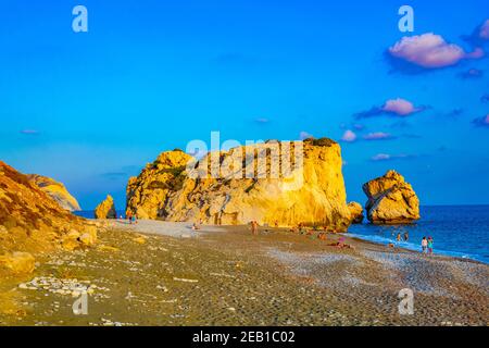 PAPHOS, CHYPRE, 20 AOÛT 2017 : les gens profitent d'une vue sur le coucher du soleil sur le rocher de Petra tou Romiou alas Aphordite sur Chypre Banque D'Images