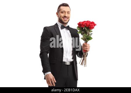 Beau homme dans un costume tenant un bouquet de rouge roses isolées sur fond blanc Banque D'Images