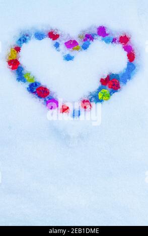 Coeur en cristaux multicolores sur la neige Banque D'Images