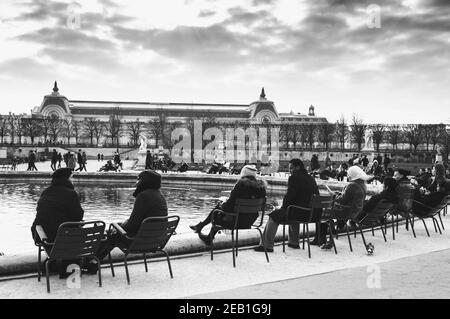 PARIS, FRANCE - 14 JANVIER 2018 : touristes et parisiens se détendant près de la fontaine du jardin des Tuileries. Musée d'Orsay en arrière-plan. Vacances d'hiver à P Banque D'Images