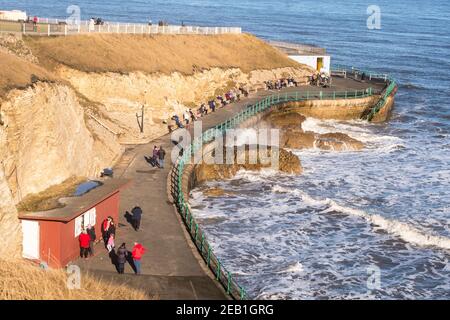 Les gens qui profitent d'une vue sur la mer et du soleil d'hiver à Roker à Sunderland, au nord-est de l'Angleterre, au Royaume-Uni Banque D'Images