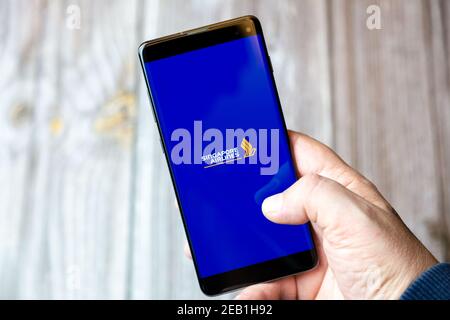 Un téléphone mobile ou mobile détenu par un Main avec l'application Singapore Airlines ouverte à l'écran Banque D'Images