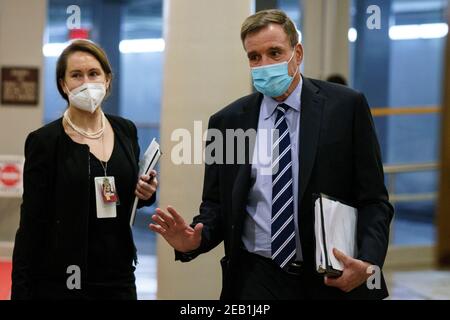 Washington, DC, États-Unis. 11 février 2021. Le sénateur Mark Warner, un démocrate de Virginie, porte un masque de protection en traversant le métro du Sénat au Capitole des États-Unis à Washington, DC, États-Unis, le jeudi 11 février 2021. Les procureurs de la Chambre ont utilisé la deuxième journée du procès de destitution de Donald Trump pour détailler une campagne de plusieurs mois menée par l'ancien président pour attiser la haine et encourager la violence à l'égard des résultats des élections, qui selon eux ont abouti à l'attaque de foule sur le Capitole des États-Unis qu'il n'a pas fait grand chose pour arrêter. Ting Shen - Pool via CNP | usage dans le monde crédit : dpa/Alay Live News Banque D'Images