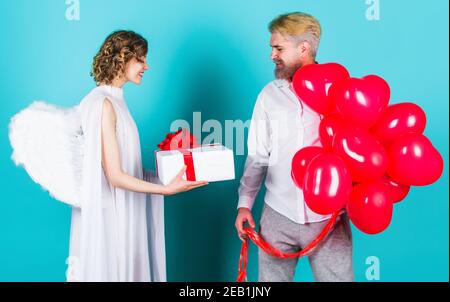 Saint-Valentin. Ange Cupidon avec des cadeaux et des ballons. Couple en Saint-Valentin. Couple charmant. Banque D'Images