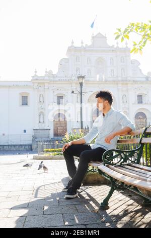 Portrait du jeune homme hispanique assis devant le Cathédrale de San Jose à Antigua Guatemala - les jeunes touristes appréciant ses vacances dans le c colonial Banque D'Images