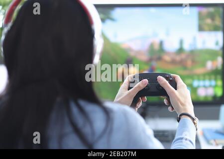 Une gameuse féminine s'assoit avec son joystick de jeu et joue sur l'ordinateur Banque D'Images