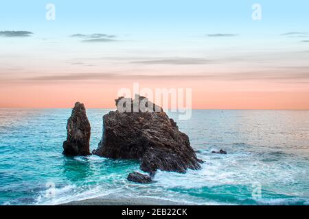 Coucher de soleil sur la mer Méditerranée et le rocher. Lieu: Monterosso al mare, cinque terre en Ligurie, Italie. Banque D'Images