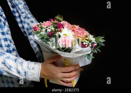 Effet de flou artistique fleurs de l'homme. Gros plan de la boîte avec des roses roses dans les mains des hommes. Les hommes donnent un bouquet pour la fête de la mère, la Saint-Valentin, la fête de la femme, l'anniversaire. Hors foyer Banque D'Images
