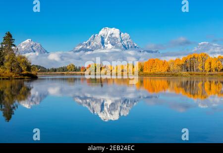 Parc national de Grand Teton, Wyoming : Mont Moran enveloppé de nuages bas reflétant les encens de couleur automnale sur l'Oxbow de la rivière Snake Banque D'Images