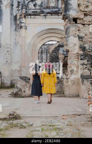 Amis marchant à travers les ruines de la cathédrale de Santiago à Antigua Guatemala - deux amis en vacances dans la ville coloniale - touristes à la découverte de nouveaux pla Banque D'Images