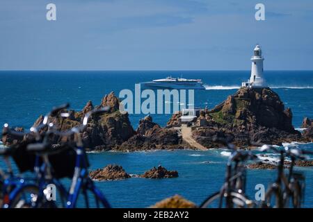 Un ferry rapide Condor passe le phare de Corbiere, Jersey, les îles Anglo-Normandes Banque D'Images