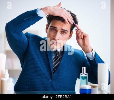 L'homme est en train de s'habiller pour aller au travail, dans la salle de bains Banque D'Images