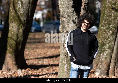 Portrait d'un jeune homme cheveux afro marchant dans la forêt À travers les bois dehors pendant l'automne Banque D'Images