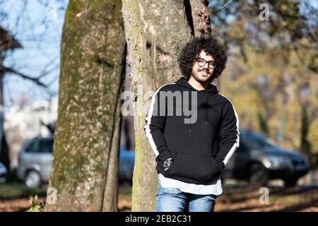 Portrait d'un jeune homme cheveux afro marchant dans la forêt À travers les bois dehors pendant l'automne Banque D'Images