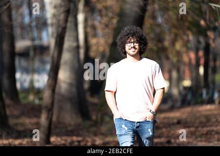 Portrait d'un jeune homme cheveux afro marchant dans la forêt À travers les bois dehors pendant l'automne Banque D'Images