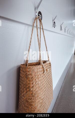 Ecology Living Zero Waste et concept durable, paille Natural Material Sac à main pour femmes suspendu sur des crochets à l'avant de la salle de repos. Réutilisable et Eco F Banque D'Images