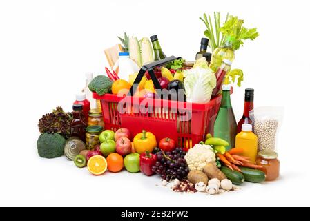 Panier de supermarché rouge plein de produits frais biologiques colorés et des produits d'épicerie avec des ingrédients variés sur fond blanc Banque D'Images