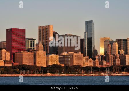 Chicago, Illinois, États-Unis. Un segment de la ligne d'horizon Loop à Chicago reflète le lever du soleil lorsqu'il traverse des nuages à l'horizon. Banque D'Images