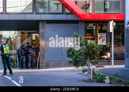 Une unité tactique spéciale de la police victorienne a été observée en attendant les commandes sous le couvert d'un levé lors de l'incident du 87 High Street, Prahran. Un incident dans la banlieue intérieure de Melbourne, Prahran, a déclenché une intervention policière majeure impliquant un groupe d'opérations spéciales et une douzaine d'agents de police, répondant à un jeune homme qui avait lancé des pierres sur la route pour s'en prendre à un immeuble. Un dommage à la propriété et à la rue couverte de pierres et de débris a stoppé la circulation jeudi matin pendant une heure et demie. Après une longue négociation avec la police, le délinquant s'est remis à la police et il a été emmené par ambulance Banque D'Images