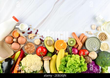 Vue de dessus des ingrédients alimentaires sains mélangés, y compris des légumes colorés et fruits sur fond de comptoir de cuisine en marbre Banque D'Images