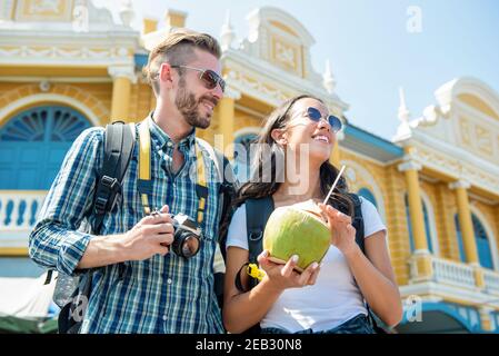 Portrait d'un heureux couple de touristes interraciaux prenant une pause avoir une boisson à la noix de coco tout en profitant de leur visite à bangkok en thaïlande Banque D'Images