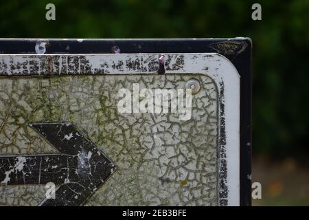 détail d'un bord d'angle fissuré et ancien d'un panneau directionnel avec flèche pointant vers la droite Banque D'Images