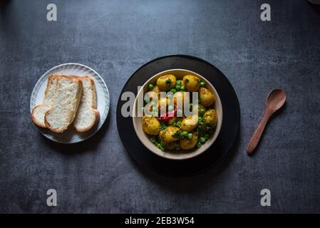 Aloo de dum indien ou pommes de terre cuites au feu lent dans un bol avec des tranches de pain. Vue de dessus, mise au point sélective. Banque D'Images