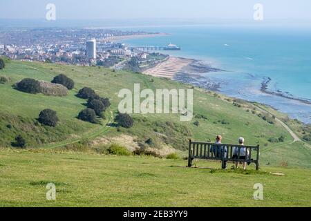 Couple senior assis sur le banc, admirez la vue sur Eastbourne, Sussex, Angleterre, GB, Royaume-Uni Banque D'Images