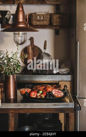 Canard rôti au four dans des fruits de saison pour les fêtes de Thanksgiving ou la fête de la veille de Noël dans un plateau à l'intérieur moderne de la cuisine. Traditionnel automne ou hiver vacances confort concept alimentaire Banque D'Images