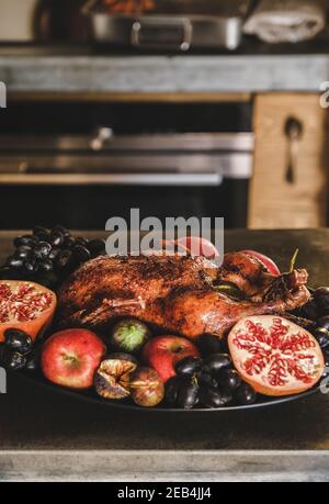 Canard rôti au four entier dans des fruits de saison mûrs pour les fêtes de Thanksgiving ou la fête de la veille de Noël sur plat, foyer sélectif. Traditionnel automne ou hiver vacances confort concept alimentaire Banque D'Images