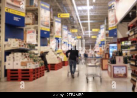 Homme avec un chariot au supermarché vue arrière défoqué. Shopping à hypermarché Banque D'Images