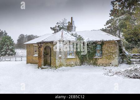 Un petit chalet rural couvert de neige. Banque D'Images