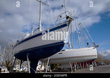 Deux yachts élégants se sont amarrés et sur des supports à Chichester Marina par une journée ensoleillée. Banque D'Images