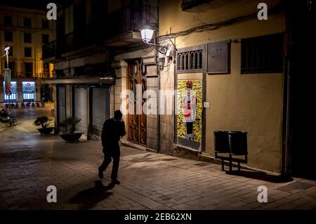 Un homme marche dans les rues solitaires du quartier gothique de Barcelone pendant le couvre-feu près d'une fresque de l'artiste de rue TvBoy représentant le président russe Vladimir Poutine en tant que meneur des menons Gru. Banque D'Images