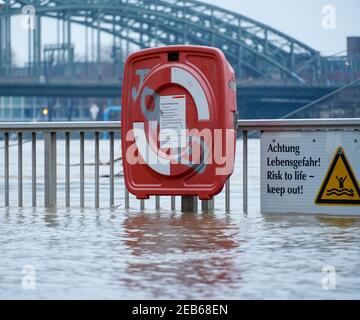 COLOGNE, ALLEMAGNE - 07 février 2021: Panneau d'avertissement, bouée de sauvetage selon la marée haute du Rhin à Cologne au milieu de l'eau courante avec le Hohenzoller Banque D'Images