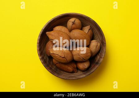 Bol avec noix de pécan savoureuses sur fond jaune Banque D'Images