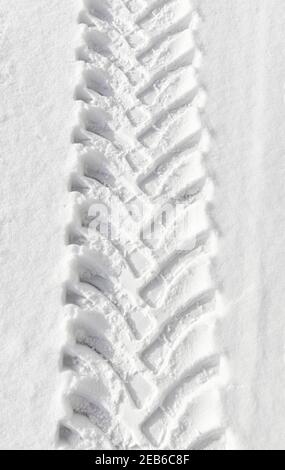 Photo d'une piste de pneus de véhicules lourds dans la neige, arrière-plan abstrait. Banque D'Images