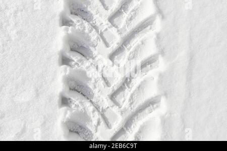 Photo d'une piste de pneus de véhicules lourds dans la neige, arrière-plan abstrait. Banque D'Images