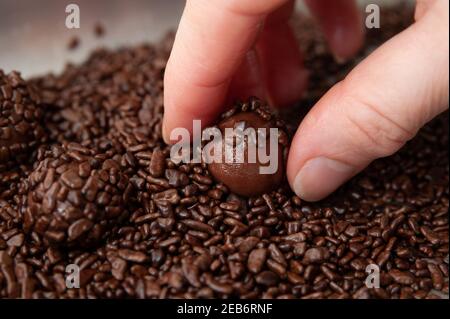 Ramassage à la main BRIGADEIRO sur plateau en aluminium le brigadeiro est un dessert brésilien traditionnel. Gros plan. Vue de dessus. Banque D'Images