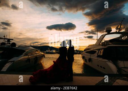 Couple s'embrassant au coucher du soleil sur une jetée de bateau Banque D'Images