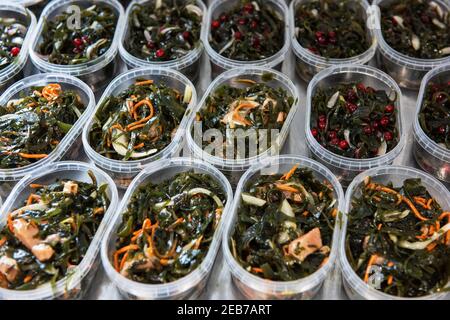 Différentes salades d'algues de poisson et de chuka wakame laminaria en plastique bowles. Concept de production ou de livraison de nourriture saine Banque D'Images