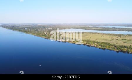 Un drone survole une rivière entourée d'un village local avec Divers bâtiments et habitats des marais et des marais avec un lit redédré De la vue aérienne de Common Reed Banque D'Images