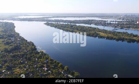 Un drone survole une rivière entourée d'un village local avec Divers bâtiments et habitats des marais et des marais avec un lit redédré De la vue aérienne de Common Reed Banque D'Images