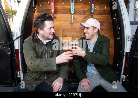 George Dean (L), ancien directeur de bar et Finn Bruce (R), réalisateur vidéo avec leur « Pub-on-Wheels » à Clapham, dans le sud de Londres. George et Finn conduisent aux portes des gens pour leur verser des pintes et créer plus d'une expérience de pub que des boîtes dans leur salon. Date de la photo : vendredi 12 février 2021. Banque D'Images