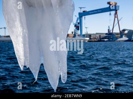 Kiel, Allemagne. 12 février 2021. Des glaces pendent d'une jetée sur le fjord de Kiel, en face du chantier naval des « chantiers navals allemands ». Credit: Axel Heimken/dpa/Alay Live News Banque D'Images