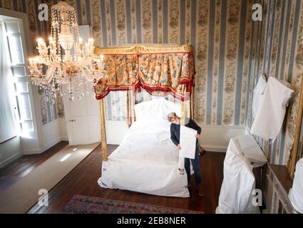 Stephen Scholey met une couche protectrice sur un spectaculaire lit doré, que le prince de Galles aurait offert au début des années 1800, à Temple Newsam House à Leeds. Au cours des dernières semaines, le personnel de Temple Newsam House a soigneusement enveloppés et recouvert des objets précieux dans l'aile sud de houseÕs, les protégeant pendant que le manoir est fermé au public pendant son confinement. Date de la photo : vendredi 12 février 2021. Banque D'Images