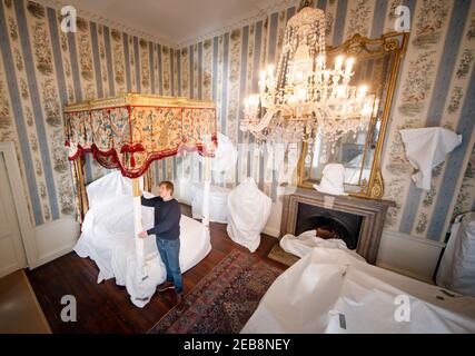 Stephen Scholey met une couche protectrice sur un spectaculaire lit doré, que le prince de Galles aurait offert au début des années 1800, à Temple Newsam House à Leeds. Au cours des dernières semaines, le personnel de Temple Newsam House a soigneusement enveloppés et recouvert des objets précieux dans l'aile sud de houseÕs, les protégeant pendant que le manoir est fermé au public pendant son confinement. Date de la photo : vendredi 12 février 2021. Banque D'Images