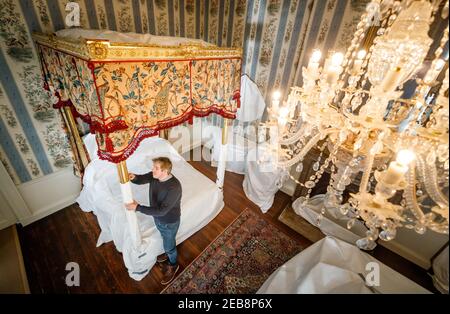 Stephen Scholey met une couche protectrice sur un spectaculaire lit doré, que le prince de Galles aurait offert au début des années 1800, à Temple Newsam House à Leeds. Au cours des dernières semaines, le personnel de Temple Newsam House a soigneusement enveloppés et recouvert des objets précieux dans l'aile sud de houseÕs, les protégeant pendant que le manoir est fermé au public pendant son confinement. Date de la photo : vendredi 12 février 2021. Banque D'Images