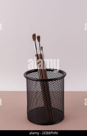 une brosse en bois pour peindre sur un fond blanc dans un porte-gobelet Banque D'Images